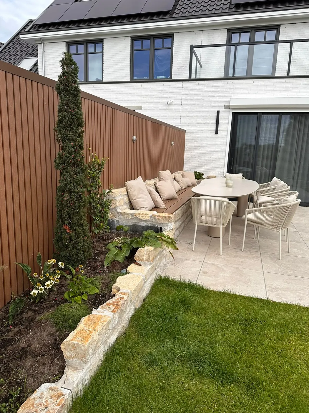 Terras met zitbank en natuursteen muurtje