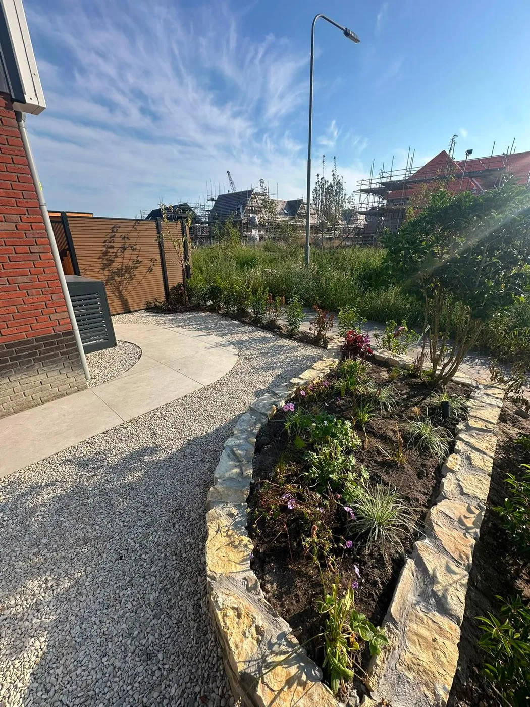 Verzorgde border met volle beplanting langs een gebogen pad