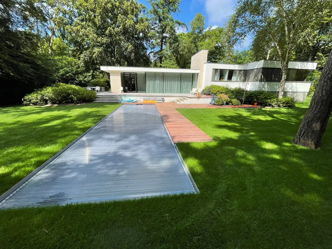 Moderne villatuin met zwembad in het gazon